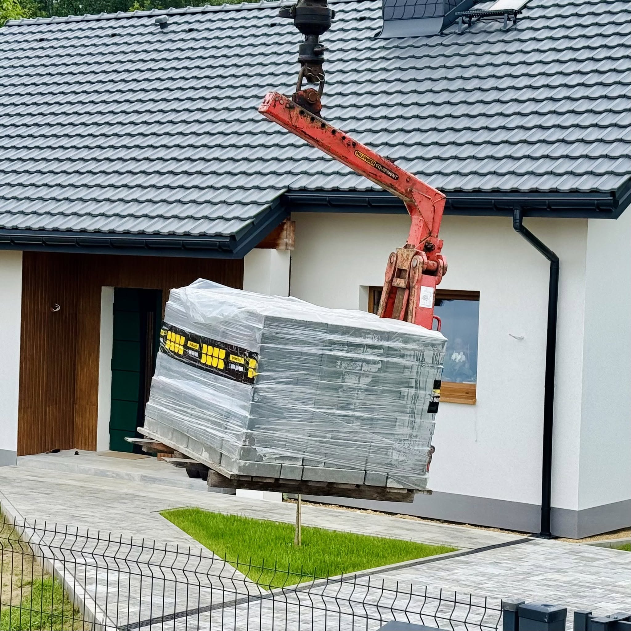 Rozładunek materiałów paletowych przed domem jednorodzinnym